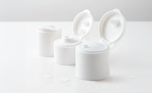 Close-up de tampas plásticas para alimentos em frascos sobre bancada inox em fábrica